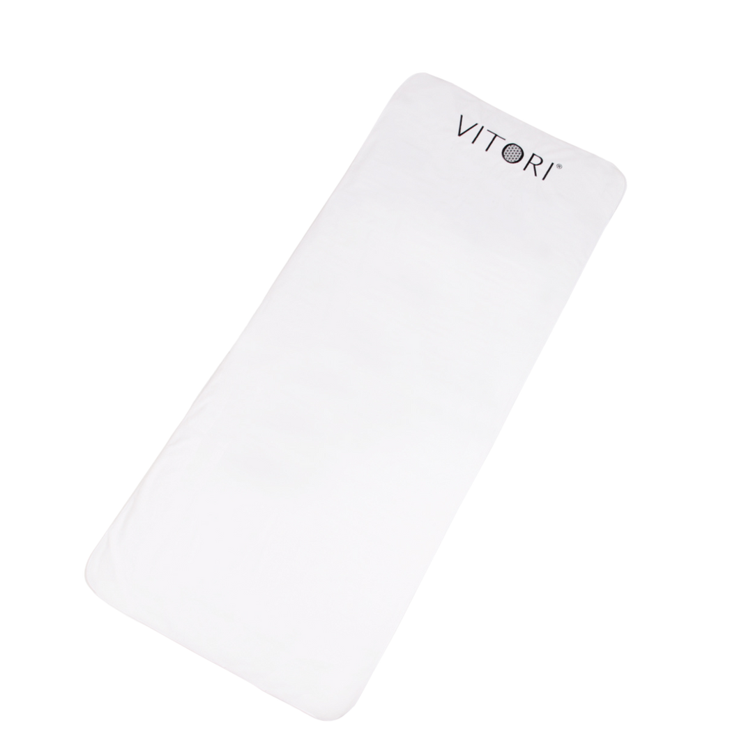 Ein rechteckiger weißer Bezug für Premium Kristallmatte von VITORI® mit abgerundeten Ecken und einer hygienischen Abdeckung zeigt an einem Ende den Markennamen in dunklen Buchstaben auf einem schlichten schwarzen Hintergrund.