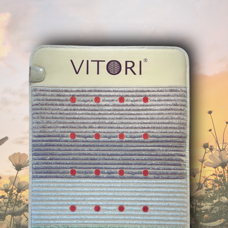 Eine rechteckige Premium Kristallmatte – Das Original von VITORI®, mit horizontalen Strukturlinien und Reihen roter kreisförmiger Elemente vor einem sanften Blumenhintergrund und einem Sonnenuntergangshimmel.