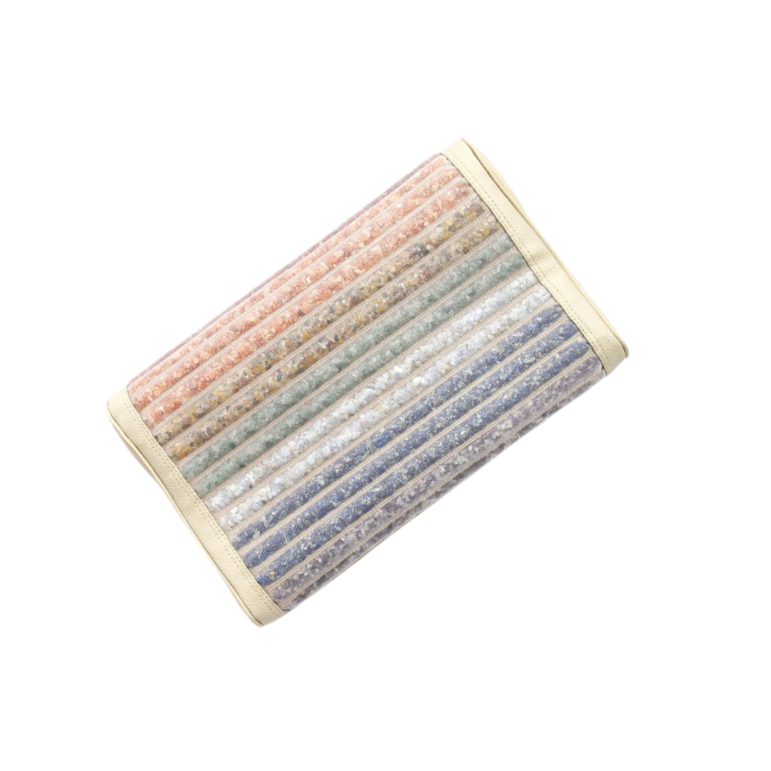 Das VITORI® Premium Kristallkissen – Das Original ist ein rechteckiges Kissen mit vertikalen Streifen in Rosa, Orange, Grün, Blau und Weiß in Pastellfarben in einem strukturierten, durchscheinenden Bezug mit cremefarbener Einfassung auf schwarzem Hintergrund.