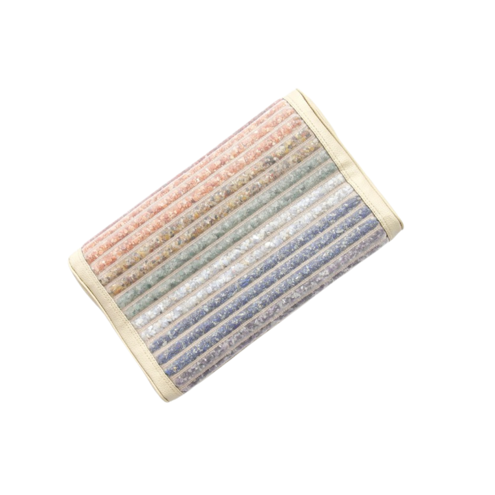 Das VITORI® Premium Kristallkissen – Das Original ist ein rechteckiges Kissen mit vertikalen Streifen in Rosa, Orange, Grün, Blau und Weiß in Pastellfarben in einem strukturierten, durchscheinenden Bezug mit cremefarbener Einfassung auf schwarzem Hintergrund.